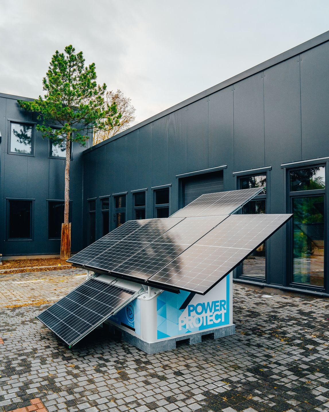 EcoGenerator z rozłożonymi panelami przy budynku